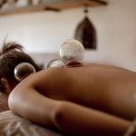 Relaxed young woman receiving cupping treatment on back, traditional chinese medicine.