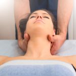 Therapist massaging the neck of woman In the by a professional