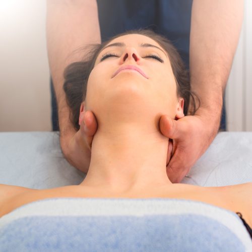 Therapist massaging the neck of woman In the by a professional